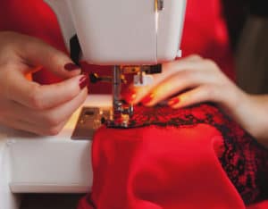 Sarta che cuce un abito da cerimonia da sartoria milano